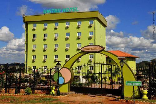 a large green hotel with a sign in front of it at United Hotel in Mbankomo