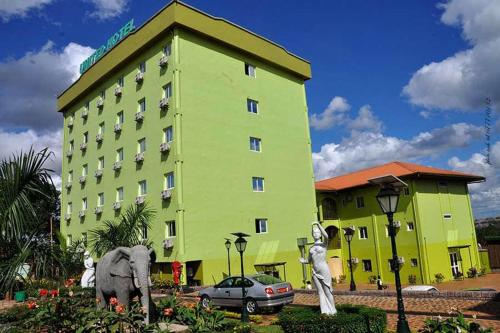 a large green building with an elephant in front of it at United Hotel in Mbankomo