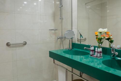 a bathroom with a green sink and a shower at Posada y Apartamentos Trebuesto de Guriezo in Trebuesto