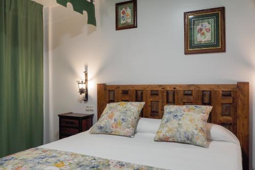 a bedroom with a white bed with two pillows at Posada y Apartamentos Trebuesto de Guriezo in Trebuesto