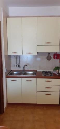 a kitchen with white cabinets and a sink at La Casa di Anna in Lampedusa