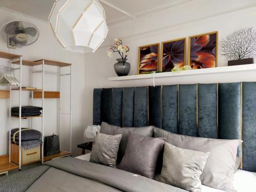 a bedroom with a bed with a blue headboard at Maya Homestay Putrajaya @ Twelve in Putrajaya