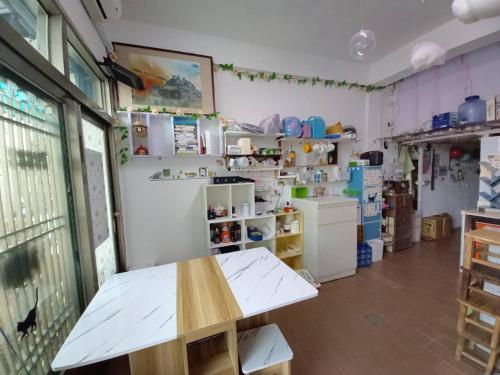 una cocina con una mesa y un refrigerador en 金門瑜仙民宿-平價住宿-機車接送-洗衣Wifi-暢遊金門, en Jinhu