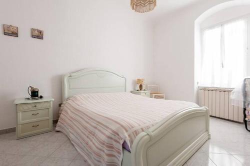 a white bedroom with a white bed and a dresser at Casa a Lerici nell'antico borgo in Lerici