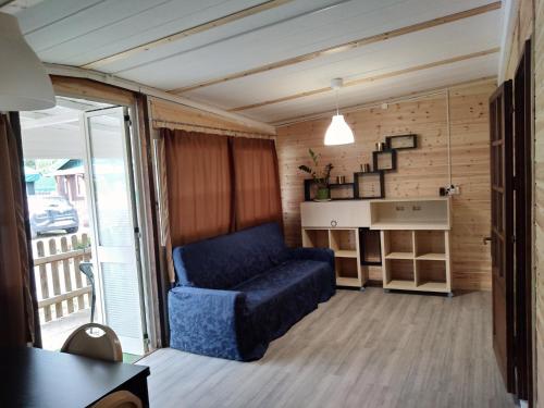 a living room with a blue couch and a balcony at Camping Pineta in Calambrone