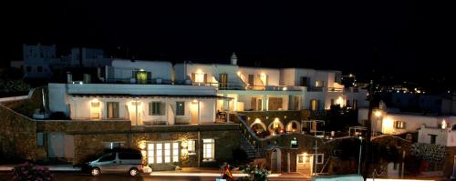 a large building with a clock on the top of it at Paolas Τown Boutique Hotel in Mikonos