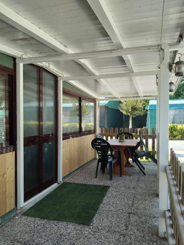 a patio with a table and chairs and a table and a table and chairs at Camping Pineta in Calambrone