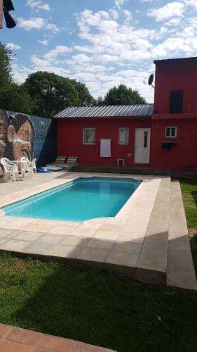 una piscina frente a una casa roja en Mi lugar Serrano 3 en Valle Hermoso