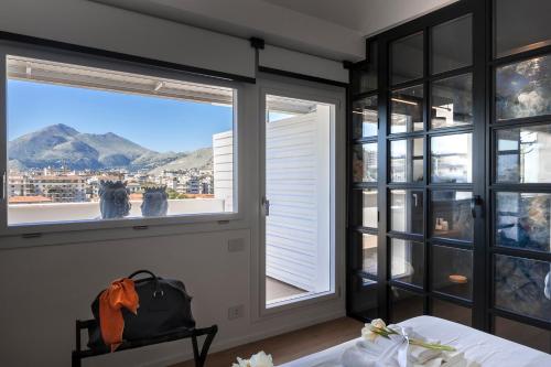 a bedroom with windows and a view of the mountains at Miceli Exclusive Suite in Palermo