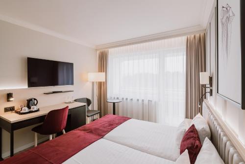 a hotel room with a bed and a desk at Ensana Sovata in Sovata