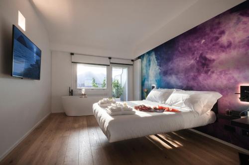 a bedroom with a large bed with a purple wall at Miceli Exclusive Suite in Palermo