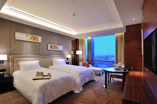 a hotel room with two beds and a large window at Dongguan Kande International Hotel in Dongguan
