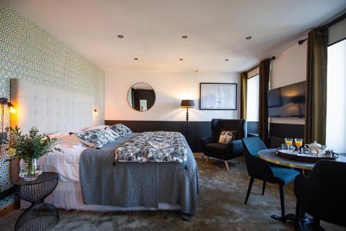 a bedroom with a bed and a chair and a table at Ty Mad Hôtel in Groix