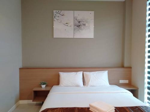 a bedroom with a large bed with white sheets at MD Boutique Hotel in Kampar