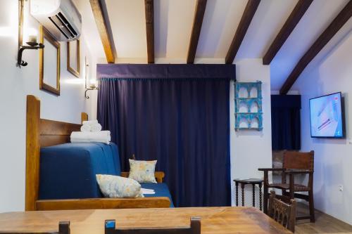 a room with a blue bed and a table at Posada y Apartamentos Trebuesto de Guriezo in Trebuesto