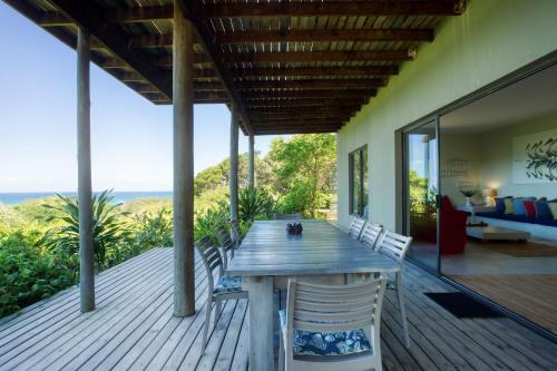 a wooden deck with a wooden table and chairs at Kangela 9 in Ponta Malongane