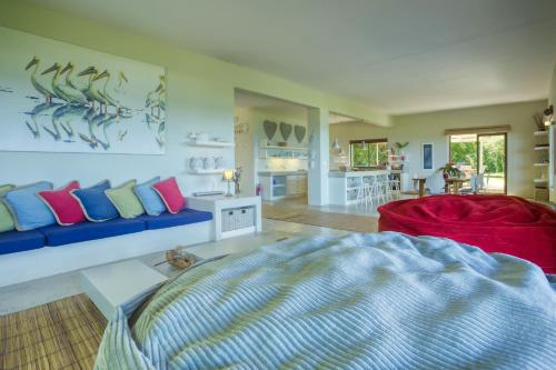 a living room with a blue couch and a red chair at Kangela 9 in Ponta Malongane