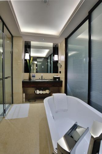 a bathroom with a white bed and a mirror at Dongguan Kande International Hotel in Dongguan