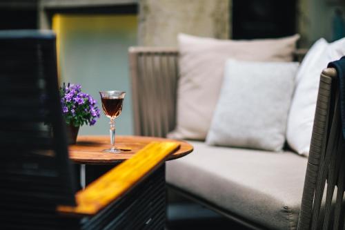 a glass of wine on a table next to a couch at The Dylan Amsterdam - The Leading Hotels of the World in Amsterdam