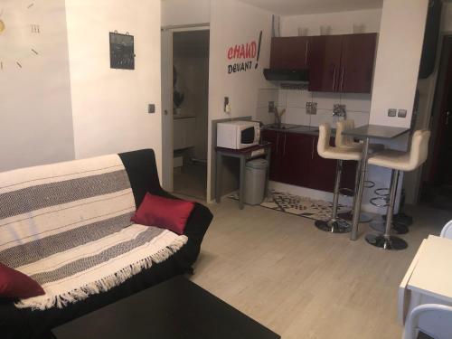 un salon avec un canapé et une cuisine dans l'établissement Avenue des Gabions résidence super deauville, à Villers-sur-Mer