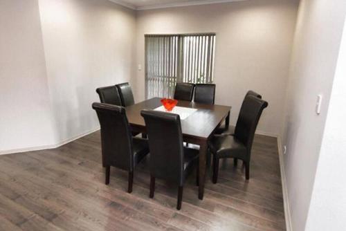 a dining room with a table and black chairs at Casavino Luxury Villa in McLaren Vale