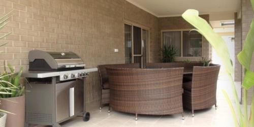 a kitchen with a stove and some chairs and a table at Casavino Luxury Villa in McLaren Vale