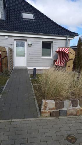 a white house with a porch and a flag on it at Nordsee-Pension Dagebüll in Dagebüll