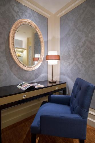 a room with a blue chair and a mirror at Dongguan Kande International Hotel in Dongguan