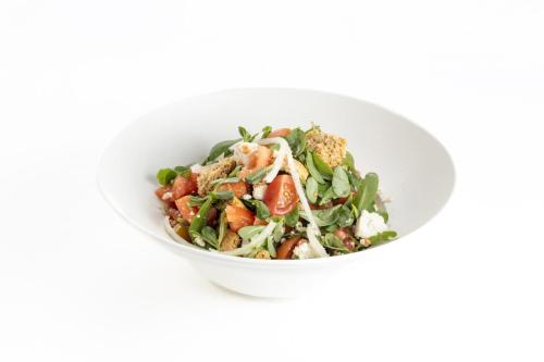a white bowl filled with a salad on a white background at Petit Palais Platres Boutique Hotel in Platres