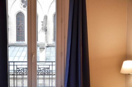 a window with a view of a building at Hôtel De La Perdrix Rouge in Paris
