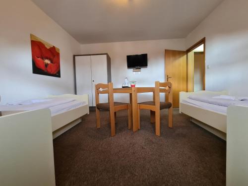 a hotel room with a table and two beds at Hotel Ceteno in Wunstorf