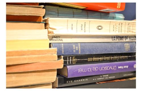 a pile of books stacked on top of each other at Hôtel De La Perdrix Rouge in Paris