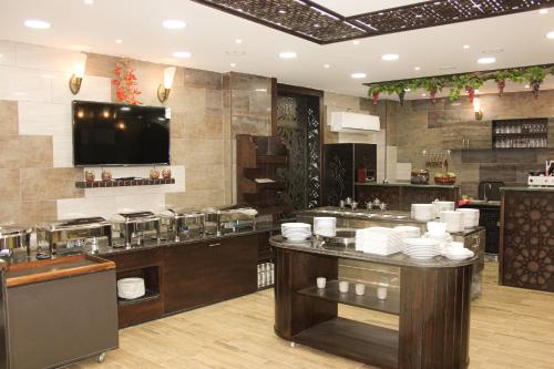 a restaurant with a counter with plates on it at Grape Village Hotel in Amman