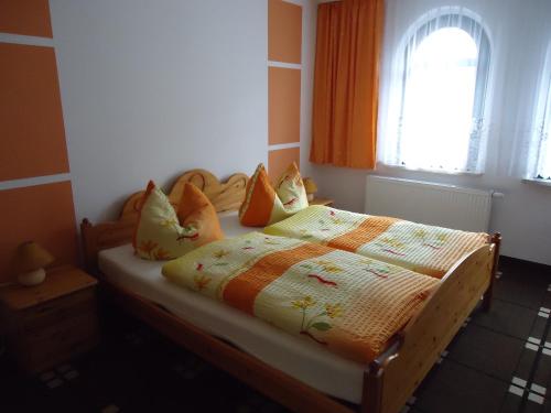a bed in a bedroom with a window at Pension Schwalbe in Zwenkau