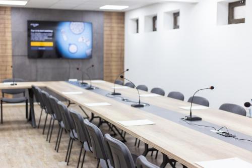 a conference room with a long table with chairs and a tv at Hotel City IN in Kochani