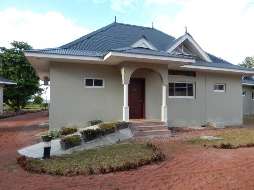 a white house with a black roof at Cote d'Or Footprints in Baie Sainte Anne