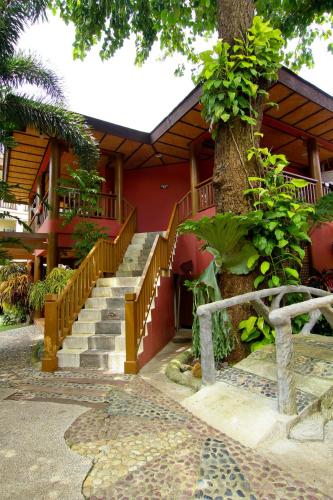 a building with stairs and a tree in front of it at Boracay Tropics Resort Hotel in Boracay