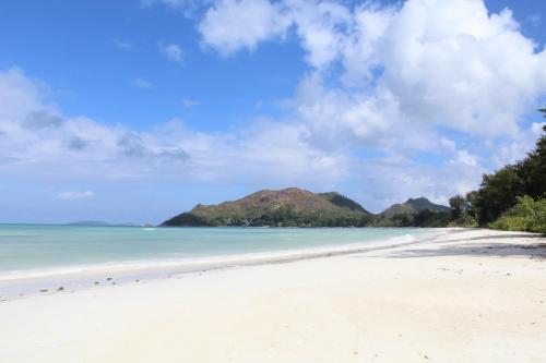 a view of a beach with mountains in the background at Cote d'Or Footprints in Baie Sainte Anne