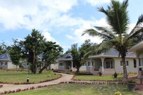 a row of houses with palm trees and a dirt road at Cote d'Or Footprints in Baie Sainte Anne