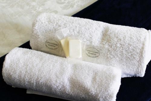 due asciugamani e una bottiglia di sapone su un tavolo di Marikal Guesthouse a Upington