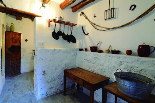 a kitchen with a tub and a table and pots and pans at La Boutique in Nuévalos