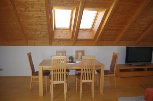 comedor con mesa, sillas y TV en Ferienwohnung Ernst, en Riedenburg