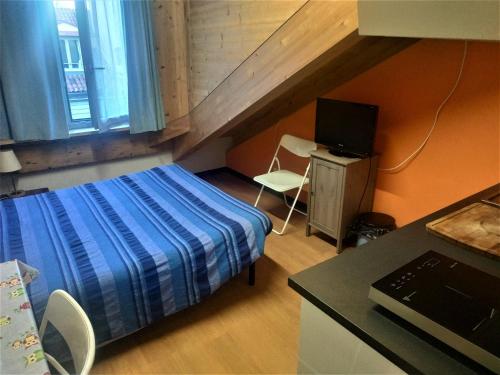 a bedroom with a bed and a desk with a television at Mansarda Arel in Turin