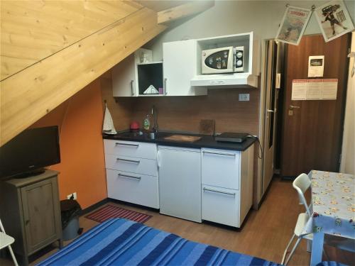 una cocina con armarios blancos y una escalera en Mansarda Arel, en Turín