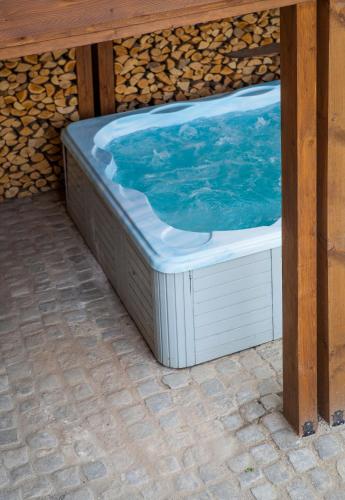 a hot tub sitting under a wooden table at Къщи за гости Сноуфлейк Snowflake Chalet and Snowflake Lodge in Bansko