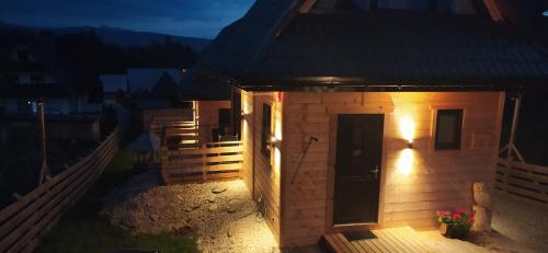 a small building with a light on the side of it at Domek w Tatrach - Osada Ostrysz in Dzianisz