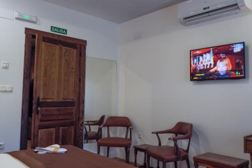 a waiting room with chairs and a tv on the wall at Posada y Apartamentos Trebuesto de Guriezo in Trebuesto