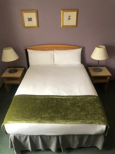 a bedroom with a large bed with two lamps at Redwings Lodge Sawtry Huntingdon in Sawtry