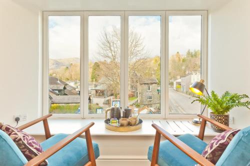 a living room with two chairs and a large window at The Apple Loft Rooms in Ambleside