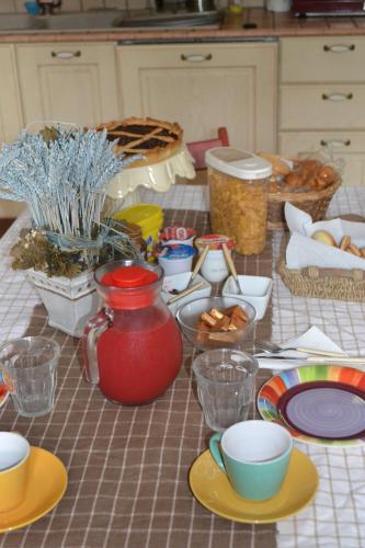 a table with plates and bowls and a red vase at B&B Pane e Rose in San Miniato